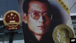 FILE - A picture of Liu Xiaobo is carried by a protester demanding the dissident's release outside China's Liaison Office in Hong Kong, Oct. 11, 2010. 