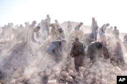 داوطلبان افغانستانی پس از زمین لرزه ۶.۳ ریشتری در حوزه «زنده‌جان» در ولایت هرات، آوارها را پس می‌زنند - ۱۹ مهر ۱۴۰۲