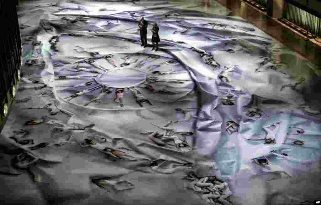 Patrons of the New York City Ballet stand on a massive photograph on linoleum flooring that features more than 80 dancers arranged in an array of poses, at the David H. Koch Theater at Lincoln Center, in New York, Jan. 28, 2014.