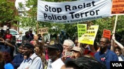 ក្រុមមនុស្ស​ធ្វើបាតុកម្ម ដោយ​មាន​កាន់​បដាសរសេរថា «សូមបញ្ឈប់​ប៉ូលិស​ភេរវជន​ដែល​រើស​អើង​ពូជសាសន៍» នៅ​ Baltimore រដ្ឋ Maryland កាលពីថ្ងៃទី២ ខែឧសភា ឆ្នាំ២០១៥។ 