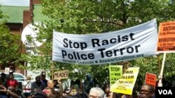 ប្រជាពលរដ្ឋ​ដើរ​ក្បួន​ដោយ​កាន់​ស្លាក​មួយ​សរសេរ​ថា​ «​បញ្ឈប់​ភេវរករ​ជា​ប៉ូលីស​រើសអើង​ពូជ​សាសន៍» នៅ​ក្នុង​ទីក្រុង​បាល់ទីម័រ រដ្ឋ​ម៉ារីឡែន​ កាល​ពី​ថ្ងៃ​ទី​២ ខែ​ឧសភា​ ឆ្នាំ​២០១៥។​