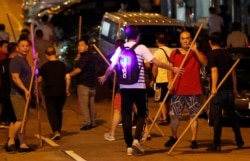 A man tries to prevent members of a group opposing anti-government protesters from clashing with people attending a demonstration in support of a city-wide strike and call for democratic reforms, Hong Kong, China, Aug. 5, 2019.
