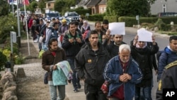 FILE - Middle Eastern migrants, who came from Germany by ferry and train Sunday night, and are walking from Rodby in southern Denmark toward Sweden.
