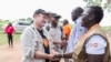 FILE - U.S. Democratic Sen. Chris Coons, left, tours Bidi Bidi in Uganda, one of the largest refugee settlements in the world, Aug. 13, 2019.