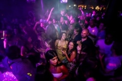 FILE - People drink shortly after the reopening at The Piano Works in Farringdon, in London, July 19, 20.