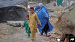 A woman walks in Kabul on Sunday wearing a burqa. The Taliban government said all women must cover their entire body when they are walking outside their homes. (AP Photo/Ebrahim Noroozi)