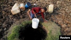 A woman fetches water from a well in Warren Park suburb, Harare, Zimbabwe, Sept. 24, 2019. 