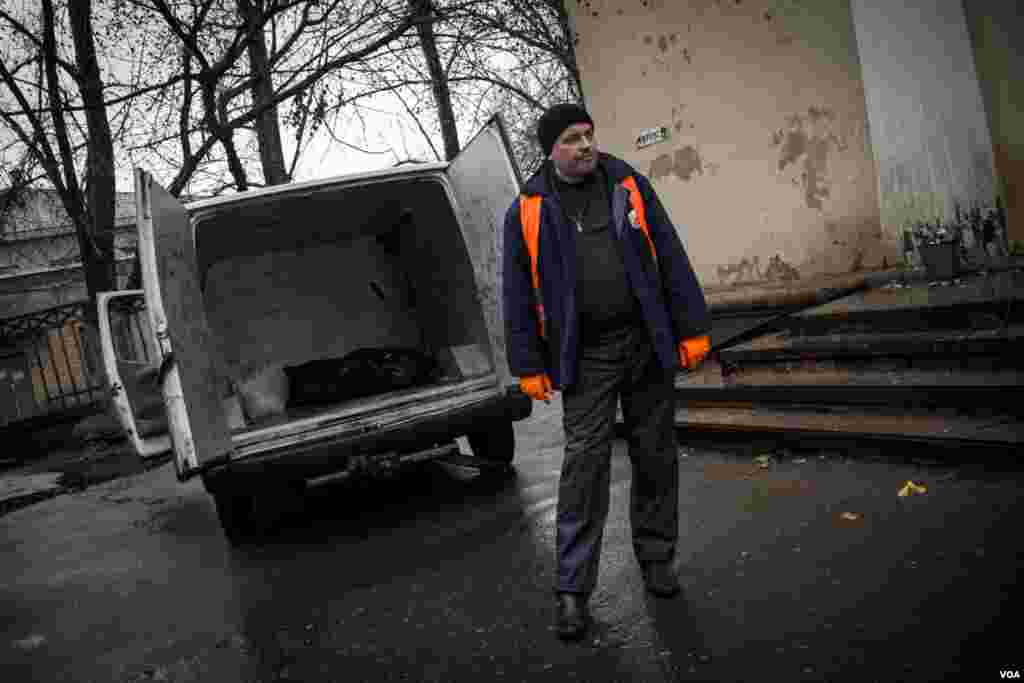The Ukraine volunteer &quot;body collector&quot; places the corpse of a pro-Russian rebel in an ambulance. The volunteers regularly cross front lines to collect the bodies of the fallen, inside Donetsk People&#39;s Republic. (Adam Bailes/VOA)