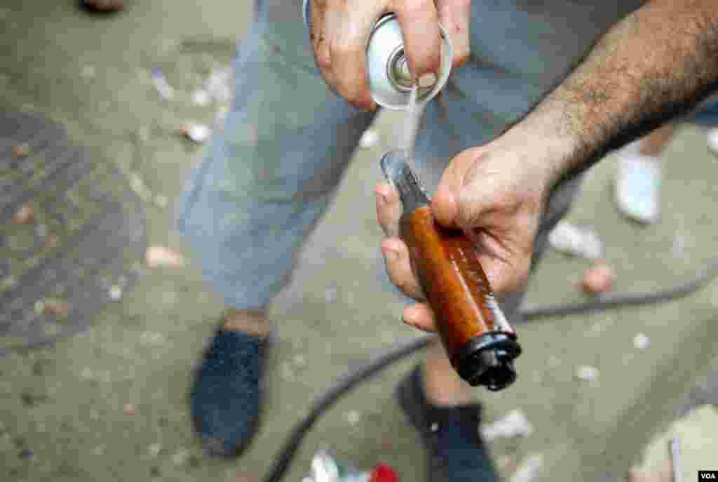 A fighter from the Bab Tabbaneh neighborhood of Tripoli, Lebanon, cleans his weapon on August 25, 2012. (VOA/Jeff Neumann)