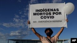 A demonstrator shows a sign reading 'Indians Killed by COVID' during a protest over Brazil's response to the coronavirus pandemic in front of the presidential palace in Brasilia, Brazil, Jan. 21, 2021.
