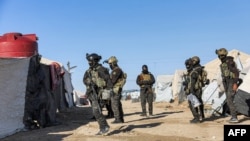 FILE - An image obtained from the media office of the Kurdish People's Protection Units in Syria (YPG) March 29, 2021 shows YPG forces conducting a security operation the previous day at the Kurdish-run al-Hol camp.