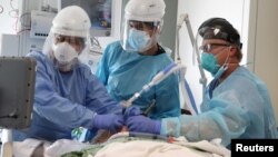 រូបឯកសារ៖ វេជ្ជបណ្ឌិត ៣ នាក់​កំពុង​ជួយសង្គ្រោះ​ជីវិត​អ្នក​ជំងឺ​កូវីដ១៩​ម្នាក់​នៅ​ក្នុង​បន្ទប់​សង្គ្រោះបន្ទាន់ ក្នុង​មន្ទីរពេទ្យ​មួយ នៅក្រុង Mission Viejo រដ្ឋ California ថ្ងៃទី៨ ខែមករា ឆ្នាំ២០២១។ 