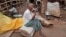 Trader smokes a cigarette as he waits for customers at a temporary cattle market for the upcoming Eid al-Adha festival in Dhaka, Bangladesh, Oct. 1, 2014.