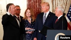 U.S. Secretary of State Mike Pompeo is sworn in by U.S. Vice President Mike Pence (R) as U.S. President Donald Trump and Susan Pompeo look on during a ceremony at the State Department in Washington, May 2, 2018.