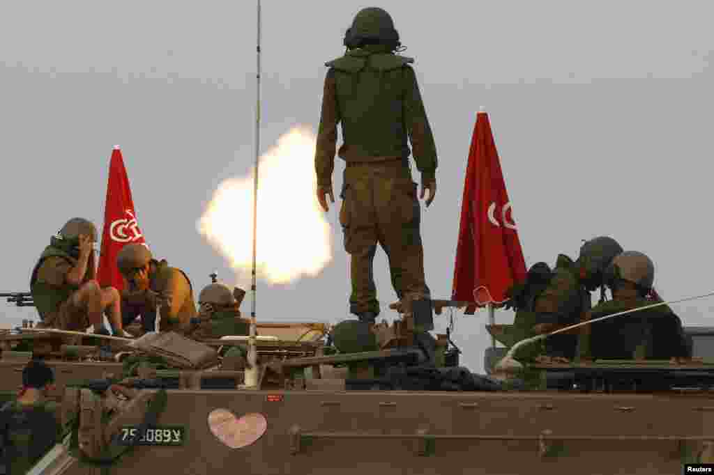 Israeli soldiers stand on an armored personnel carrier outside the central Gaza Strip as they fire mortar shell towards Gaza before a cease-fire, Aug. 1, 2014.