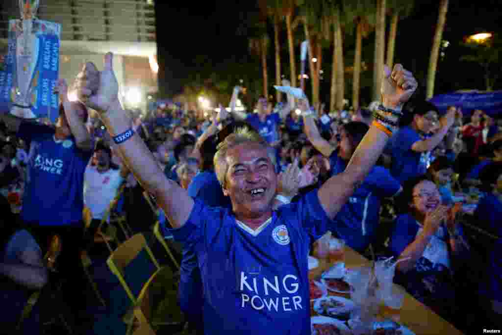 Leicester City fans celebrate after their team scores against Manchester United while watching the game on a big screen, in Bangkok, Thailand.