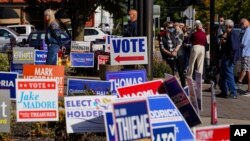 FILE - Voters wait in line to cast their ballots on the second day of early voting in in Noblesville, Indiana, Oct. 7, 2020.