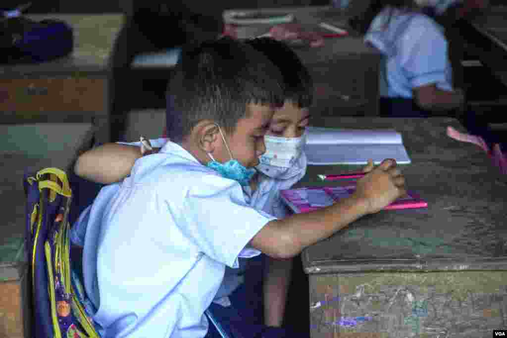 កុមារ​​កម្ពុជា​ពាក់ម៉ាស​ ចូលរៀន​​ក្នុង​ថ្នាក់​រៀន​​ តាម​ការ​កំណត់​របស់​ក្រសួង​អប់រំ​ យុវជន​ និង​កីឡា​ ​ក្រោយ​ការ​រំខាន​ដោយ​ជំងឺ​កូវីដ​១៩​ អស់​ពេល​ជាច្រើន​ខែ រាជធានីភ្នំពេញ​ ថ្ងៃ​ទី១​ ខែ​វិច្ឆិកា​ ឆ្នាំ​២០២១។​ (ហ៊ាន សុជាតា​/វីអូអេ)