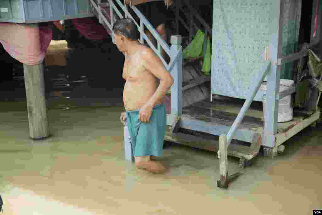 លោក ថន ហន អាយុ ៦៧ឆ្នាំ ពិនិត្យមើលស្ថានភាពទឹកជន់លិចផ្ទះរបស់លោក នៅស្រុកកណ្តាលស្ទឹង ខេត្តកណ្តាល ថ្ងៃទី១៤ ខែតុលា ឆ្នាំ២០២០។ (ទុំ ម្លិះ/វីអូអេ)