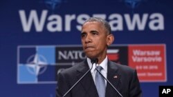 President Barack Obama pauses while speaking about the events in Dallas at the beginning of his news conference at PGE National Stadium in Warsaw, July 9, 2016. 