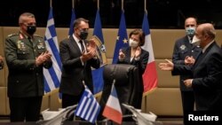 French Defense Minister Florence Parly and her Greek counterpart applaud after the signing of an agreement for the purchase of 18 Rafale fighter jets at the Greek Defense Ministry in Athens, Jan. 25, 2021. (Louiza Gouliamaki/Pool via Reuters)