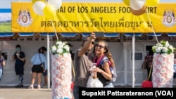 A couple takes a selfie in front of the Wat Thai of Los Angeles Food Court at Wat Thai (Thai Temple) of Los Angeles, North Hollywood, CA. November 06, 2021.