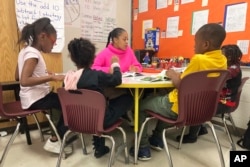 Third-grade teaching assistant Keione Vance leads a reading session with a small group of students at Boyd Elementary School in Atlanta, Dec. 15, 2022. (AP Photo/Sharon Johnson)