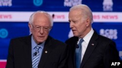 Bernie Sanders (G) et l'ex vice-président Joe Biden sur scène pour le dixième débat primaire démocrate de la campagne présidentielle de 2020 co-organisé par CBS News et le Congressional Black Caucus Institute à Charleston, Caroline du Sud, le 25 février 2020. (Ph. J. WATSON/AFP)