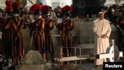 Pope Francis stands next to members of the Vatican Swiss guard band in St. Peter's Square at the Vatican, Dec. 31, 2016. 