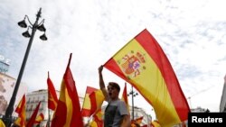 Demonstran melambaikan bendera Spanyol dalam aksi demo mendukung persatuan Spanyol di hari pelaksanaan referendum kemerdekaan di Catalonia, di Madrid, 1 Oktober 2017. Pemerintah Spanyol telah melarang pelaksanaan pemungutan suara tersebut.