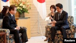 Suh Hoon, Kepala Dinas Intelijen Nasional Korea Selatan (kiri) bertemu dengan Perdana Menteri Jepang Shinzo Abe di Tokyo, Jepang, 13 Maret 2018.