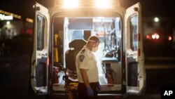 បុគ្គលិក​ផ្នែក​សង្គ្រោះ​បន្ទាន់ ផ្អាក​មួយ​សន្ទុះ ក្រោយពី​បញ្ជូន​អ្នកជំងឺ​ម្នាក់​ទៅ​មន្ទីរពេទ្យ​មួយ​កន្លែង​នៅ​ទីក្រុង Cranston រដ្ឋ Rhode Island កាលពី​ថ្ងៃអង្គារ​ទី១ ខែធ្នូ ឆ្នាំ២០២០។