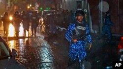 在总统亚明宣布紧急状态后，马尔代夫警察手持警棍冲向首都马累街头的抗议者。（2018年2月6日）