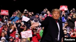 ប្រធានាធិបតី​សហរដ្ឋអាមេរិក​លោក Donald Trump គ្រវែង​ម៉ាស់​ទៅ​លើ​ហ្វូង​អ្នក​គាំទ្រ​ ខណៈ​ដែល​លោក​មក​ដល់​កន្លែង​ជួបជុំ​អ្នក​គាំទ្រ​នៅ​ក្រុង Johnstown រដ្ឋ Pennsylvania ថ្ងៃទី១៣ ខែតុលា ឆ្នាំ២០២០។ 