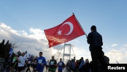 Un homme tient un drapeau turc lors du 38e marathon d'Istanbul, Turquie, le 13 novembre 2016. 