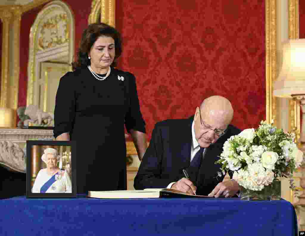 Prime Minister of Lebanon Najib Mikati signs a book of condolence as his wife May Mikati stands next to him at Lancaster House, following the death of Queen Elizabeth II, in London, Sept. 18, 2022.