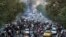 
In this Sept. 21, 2022, photo taken by an individual not employed by the Associated Press and obtained by the AP outside Iran, demonstrators block a street during a protest over the death of a woman who was detained by the country's morality police, in downtown Tehran.