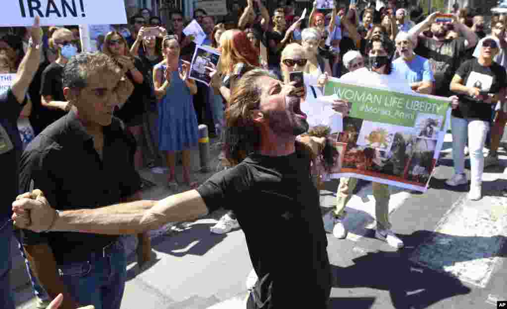 People shout slogans during a protest against the death of Iranian Mahsa Amini, outside the Iranian Embassy, in Nicosia, Cyprus, Sept. 25, 2022. 