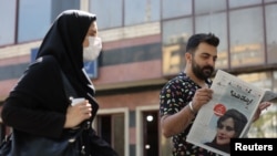 A man views a newspaper with a cover picture of Mahsa Amini, a woman who died after being arrested by the Islamic republic's "morality police" in Tehran, Iran, Sept. 18, 2022. (Majid Asgaripour/WANA via Reuters)