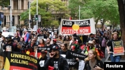 Warga pribumi Australia dan para pendukungnya berpawai di tengah kota Sydney, untuk "menghapus monarki" pada saat hari berkabung wafatnya Ratu Inggris Elizabeth, 22 September 2022. (Foto: Jaimi Joy/Reuters)