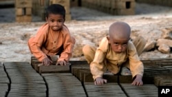 FILE - Afghan children work in a brick factory on the outskirts of Kabul, Afghanistan, July 26, 2022.
