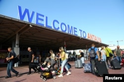 Tourists, coming mainly from Russia, leave from the arrival terminal at Antalya International Airport in the Mediterranean resort city of Antalya, Turkey, Sept. 22, 2022.