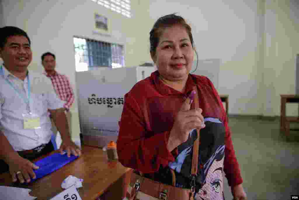 មន្ត្រី​ក្រុម​ប្រឹក្សា​សង្កាត់​មួយ​រូប​បង្ហាញ​ទឹក​ដៃ​ជ្រលក់​ថ្នាំ​បន្ទាប់​ពី​បាន​បោះ​ឆ្នោត​ជ្រើស​រើស​ព្រឹទ្ធ​សភា ​ក្នុង​ការិយាល័យ​​បោះ​ឆ្នោត​​មួយ​​កន្លែង​​នៅ​​ក្រុង​​ភ្នំពេញ ​កាលពីថ្ងៃទី២៥ ​ខែកុម្ភៈ ​ឆ្នាំ២០១៨។ ​(អូន ឆេងប៉រ/VOA)