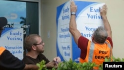 Des employés mettent des affiches dans les rues du comté de Miami-Dade pour annoncer le vote anticipé, le 12 octobre 2016.