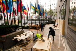 Workers board up a store in Rockefeller Center in New York ahead of Tuesday's contentious presidential election, Nov. 2, 2020.