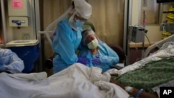 Seorang perawat tengah menemani keluarga pasien Covid-19 yang tengah dirawat di St. Jude Medical Center, Fullerton, California, 31 Juli 2020. (AP Photo/Jae C. Hong)