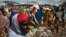 FILE - Somali refugees organize their collected ration of food during a distribution exercise outside a United Nations World Food Program center at a refugee settlement in Dadaab, Kenya, October 2013.