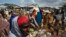 FILE - Somali refugees organize their food rations during a distribution exercise outside a U.N. World Food Program center at the Dadaab refugee settlement in Kenya, October 2013.