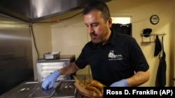 In this Thursday, October 10, 2019 photo, Jose Gamiz, a co-owner at the Mi Vegana Madre restaurant, prepares fresh vegan tacos in Glendale, Arizona.