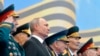 FILE - Flanked by World War II veterans, Russian President Vladimir Putin watches a military parade marking 74 years since the end of World War II, in Red Square, in Moscow, Russia, May 9, 2019.